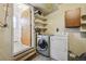Functional laundry area with washer, dryer, shelving, and access to the exterior at 4655 Independence St # 3, Wheat Ridge, CO 80033