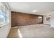 Bright, carpeted living room featuring a charming brick accent wall and large windows at 4655 Independence St # 3, Wheat Ridge, CO 80033