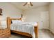Bright bedroom features a wooden bed frame, soft carpet, and a ceiling fan at 16516 Fairbanks Rd, Platteville, CO 80651