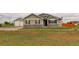 Inviting home exterior featuring stone accents, well-maintained lawn, and detached garage at 16516 Fairbanks Rd, Platteville, CO 80651