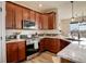Gourmet kitchen featuring granite countertops, stainless steel appliances, and rich wood cabinetry at 16516 Fairbanks Rd, Platteville, CO 80651