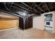 Unfinished basement features exposed ceiling, wood accent wall and in-unit laundry area at 3320 N Columbine St, Denver, CO 80205