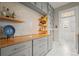 Charming butler pantry with grey cabinets, floating shelves, stylish wallpaper and butcher block countertops at 3320 N Columbine St, Denver, CO 80205