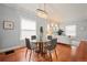 Bright dining area with a glass table, chandelier and hardwood floors, connects to a cozy living room at 3320 N Columbine St, Denver, CO 80205
