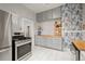 Stylish kitchen featuring grey cabinets, floating shelves and stainless steel appliances at 3320 N Columbine St, Denver, CO 80205
