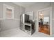 Galley kitchen with stainless steel appliances, white tile floors and ample natural light at 3320 N Columbine St, Denver, CO 80205