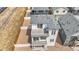 Modern two-story home featuring two balconies, white siding, and a fenced yard with a patio at 5147 N Waco St, Denver, CO 80249
