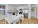 Modern kitchen with white cabinetry, stainless steel appliances, and a dining area with hardwood floors at 5147 N Waco St, Denver, CO 80249