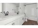 Bright bathroom featuring dual sinks, white cabinets, quartz countertops, and modern black hardware at 25214 E Warren Pl, Aurora, CO 80018