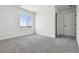 Clean, light-filled bedroom with neutral carpet and a large window showcasing scenic neighborhood views at 25214 E Warren Pl, Aurora, CO 80018