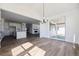 Open-concept dining area with hardwood floors, modern chandelier, and a sliding door at 25214 E Warren Pl, Aurora, CO 80018