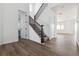Bright entryway featuring hardwood floors and a staircase with elegant wood railing and white risers at 25214 E Warren Pl, Aurora, CO 80018