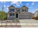 Inviting two-story home with stone accents, a three-car garage, and a charming front porch at 25214 E Warren Pl, Aurora, CO 80018