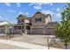 Charming two-story home featuring a three-car garage, stone accents, and a cozy front porch at 25214 E Warren Pl, Aurora, CO 80018