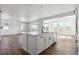 Bright kitchen boasts a large island with a sink, white cabinets, and hardwood floors at 25214 E Warren Pl, Aurora, CO 80018