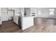 Beautiful kitchen island features a stainless steel dishwasher, undermount sink, and wood floors at 25214 E Warren Pl, Aurora, CO 80018