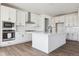 Modern kitchen with stainless steel appliances, white cabinets, and a central island at 25214 E Warren Pl, Aurora, CO 80018