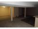 Bright basement featuring neutral walls, carpeted floors, columns and door to stairs at 12381 E Vassar Dr, Aurora, CO 80014