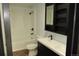 Clean bathroom featuring a white shower-tub combo, toilet, and dark vanity with a modern sink and storage at 12381 E Vassar Dr, Aurora, CO 80014