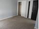 Bedroom features carpet and large sliding closet doors for convenient storage at 12381 E Vassar Dr, Aurora, CO 80014