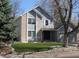 Charming two-story home featuring blue siding, brick accents, well-maintained lawn and mature trees at 12381 E Vassar Dr, Aurora, CO 80014
