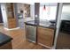 Kitchen with granite countertops, breakfast bar, wine fridge, and view into living room at 12381 E Vassar Dr, Aurora, CO 80014