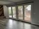 Bright living room featuring gray laminate flooring, a brick fireplace, and french doors to the backyard at 12381 E Vassar Dr, Aurora, CO 80014
