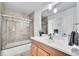 Bathroom with a glass-enclosed shower, wood vanity, and decorative light fixtures, offering a modern and clean design at 5158 W Lake Pl, Littleton, CO 80123