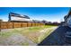 Wide backyard with a wooden privacy fence and back view of other houses in the community at 56607 E 23Rd Ave, Strasburg, CO 80136