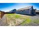 A large backyard featuring fresh sod surrounded by gravel and a back entrance to the home at 56607 E 23Rd Ave, Strasburg, CO 80136