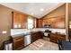 Well lit kitchen featuring stainless steel appliances, dark counters, and stylish brown cabinetry at 56607 E 23Rd Ave, Strasburg, CO 80136