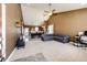 Spacious living room with vaulted ceilings, carpet floors, and an open layout that flows into the kitchen at 56607 E 23Rd Ave, Strasburg, CO 80136