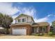 Charming two-story brick home featuring an attached two-car garage, well-manicured lawn, and beautiful blue skies at 19033 E 22Nd Cir, Aurora, CO 80011