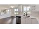 Bright kitchen featuring stainless steel dishwasher and sink, white cabinets, and hardwood floors at 19033 E 22Nd Cir, Aurora, CO 80011