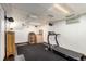 Finished basement area features black carpet, white walls, and a treadmill for at-home workouts at 3411 S Olathe Way, Aurora, CO 80013