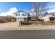 Inviting home featuring mature trees, a well-manicured lawn, and a spacious driveway at 3411 S Olathe Way, Aurora, CO 80013