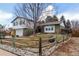 Landscaped split-level home with manicured lawn, trees, and a charming wooden fence at 3411 S Olathe Way, Aurora, CO 80013