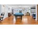 Spacious basement featuring a pool table, built-in bookshelves, and hardwood floors at 4321 Winona Ct, Denver, CO 80212