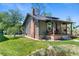 Side exterior of home with brick foundation and chimney, lush lawn, and covered porch at 4321 Winona Ct, Denver, CO 80212