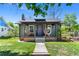 Charming home with a cozy front porch, green lawn, and distinctive purple door at 4321 Winona Ct, Denver, CO 80212