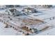 Aerial view of a house with a horse stable and snowy pasture at 16122 Emporia Way, Brighton, CO 80602