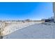 Snowy backyard with a view of a horse pasture and neighboring houses at 16122 Emporia Way, Brighton, CO 80602