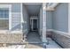 Covered entryway with stone accents and a dark-colored front door at 16122 Emporia Way, Brighton, CO 80602