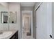 Bright bathroom featuring a sleek vanity with dual mirrors and a doorway leading to another bathroom area at 2454 Ambience Ln, Castle Rock, CO 80109