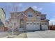 Charming two-story home with a three car garage and inviting front entrance with stone details at 2454 Ambience Ln, Castle Rock, CO 80109