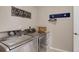 Modern laundry room with stainless steel washer and dryer, and ample storage space at 2454 Ambience Ln, Castle Rock, CO 80109