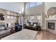 Open-concept living area with fireplace, tall windows, and hardwood floors at 2454 Ambience Ln, Castle Rock, CO 80109