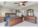 Elegant primary bedroom with a king-sized bed, dark wood furniture, and a view into the bathroom at 2454 Ambience Ln, Castle Rock, CO 80109