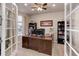 Bright office with large desk, built-in shelving, and elegant French doors at 2454 Ambience Ln, Castle Rock, CO 80109