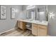 Bright bathroom featuring double sinks, a large mirror, and new hardwood floors at 4013 S Carson St # C, Aurora, CO 80014